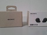 the box of the sony earphones is next to the box of the headphones