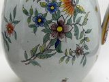 a white tea pot with a floral design on it