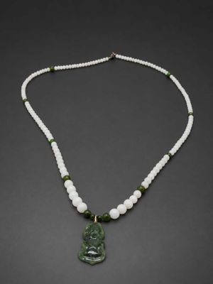 a green jade buddha pendant with white pearls and green jade beads
