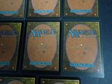 six decks of magic the gathering cards laid out on a table