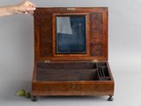 une personne tenant une petite boîte en bois contenant un miroir