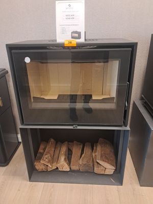 une cheminée sur laquelle sont empilées des bûches, dans un coin de la pièce