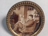 a picture of a man sitting on a chair reading a book