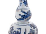 un vase bleu et blanc posé sur une surface blanche