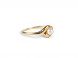 a gold ring with a pearl in the middle