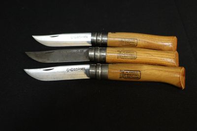 three knives that are sitting on a black surface