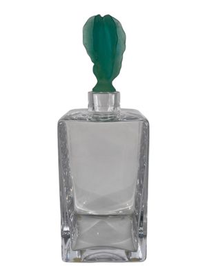 an image of a bottle of perfume with a green top