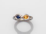 un gros plan d'une bague ornée de deux pierres de couleurs différentes