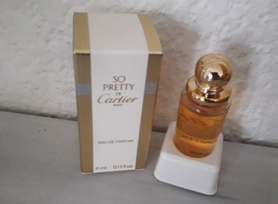 l'image d'un flacon de parfum posé à côté d'une boîte