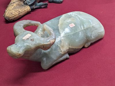 a statue of an elephant sitting on a table next to a pair of shoes
