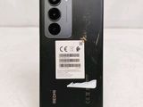the back of a black phone with a barcode sticker on it
