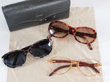 three pairs of sunglasses and a black case on a table