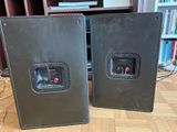 two speakers that are sitting on a wooden floor