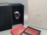 une boîte ouverte contenant une montre, avec un carnet à côté