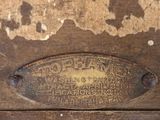 a metal plaque on the side of a wooden cabinet