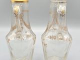 pair of clear glass vases with gold rims on a white surface
