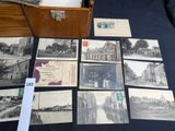 an old photo of a bunch of old postcards on a table