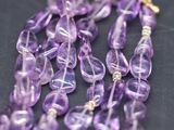 a close up of a bunch of purple glass beads on a black surface