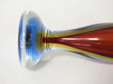 a colorful glass vase sitting on a white surface