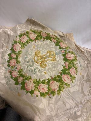 un oreiller blanc orné de roses roses, posé sur un lit