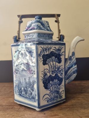 a blue and white teapot sitting on a wooden table