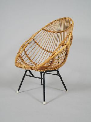 a close up of a rattan chair on a metal stand
