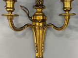 brass wall sconce with two candle holders on a white wall