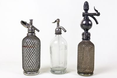 trois bouteilles en verre posées les unes à côté des autres sur une table