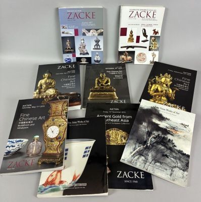 several books on a table with a clock on top of it