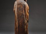 a wooden statue of a man in a robe and hat