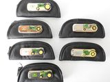 four black leather pencil cases with a green tractor on them