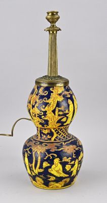 une image représentant un vase bleu et or surmonté d'une lampe