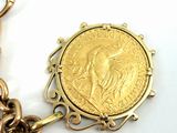 a gold coin on a chain that is attached to a chain
