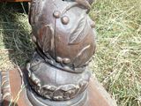 une statue représentant un ours assis sur une table en bois