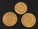 three gold sovereigns on a black background