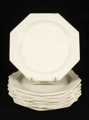 plusieurs assiettes blanches empilées les unes sur les autres sur une surface noire