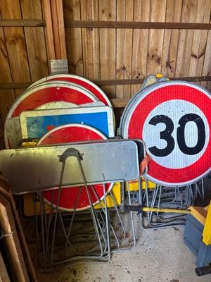 many different signs that are sitting in a garage