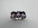 a close up of a ring with two amethtites on it