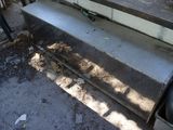 a bench that is sitting on the side of the house
