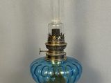 une lampe en verre bleu posée sur une table