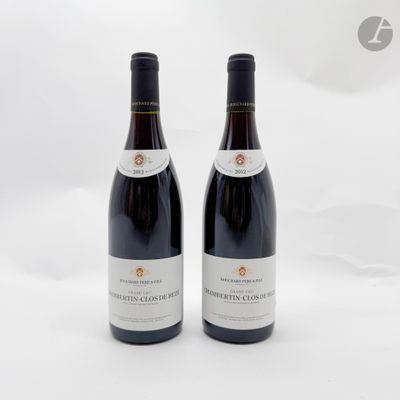 deux bouteilles de vin rouge posées l'une à côté de l'autre sur une surface blanche