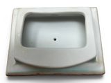 a small white sink sitting on top of a white counter