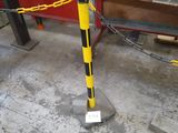 un poteau jaune et noir entouré d'une chaîne