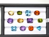 several different colored gems in a black box on a white surface