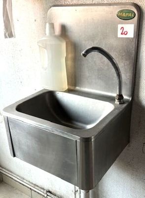 a stainless steel sink with a soap dispenser attached to it