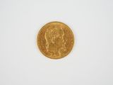 gros plan d'une pièce d'or sur une surface blanche