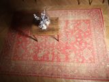 un tapis rouge posé sur un parquet, à côté d'une table basse