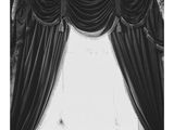 black and white photograph of a woman laying on a bed in front of a window