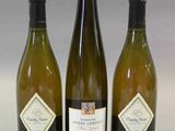 trois bouteilles de vin posées l'une à côté de l'autre sur une table