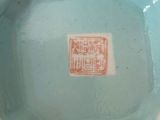 a small blue bowl with a red stamp on it